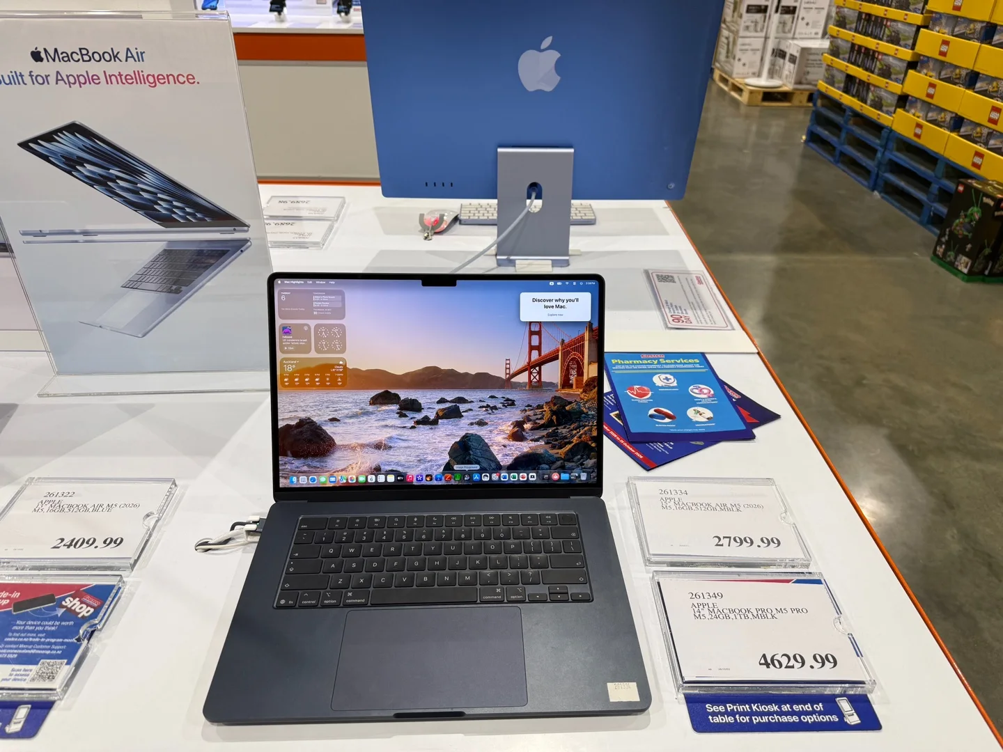 진열대에 놓인 MacBook과 가격표 세 장. 2409.99, 2799.99, 4629.99라고 적혀 있다