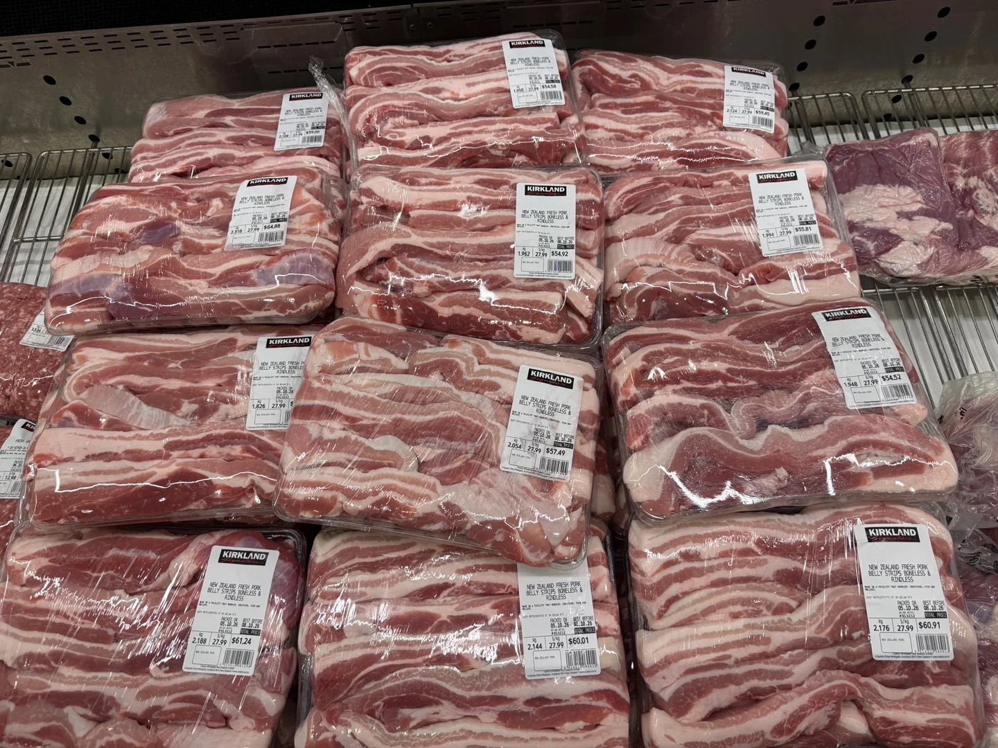 길게 자른 삼겹살이 담긴 팩들. 라벨에 New Zealand Fresh Pork Belly Strips Boneless & Rindless, kg당 27.99라고 적혀 있다
