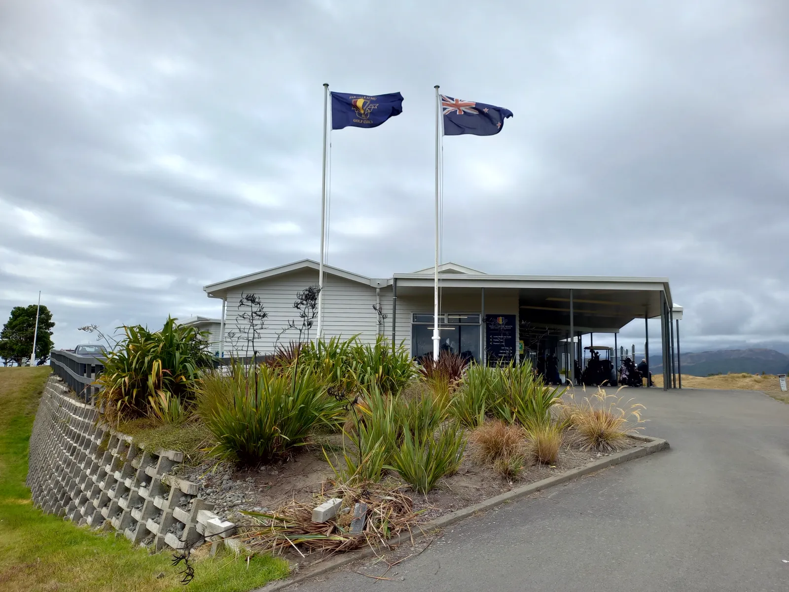 깃발 두 개가 걸린 Paraparaumu Beach Golf Club 클럽하우스 입구